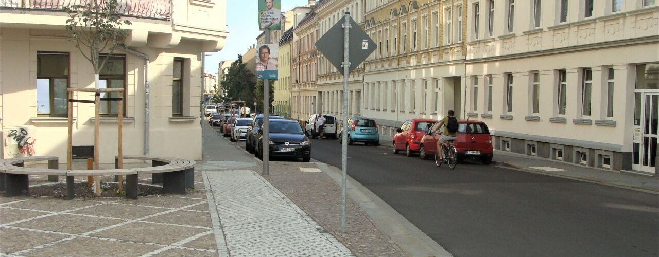 neu gestalteter Kreuzungsbereich zwischen Gießerstraße und Rolf-Axen-Straße mit Straßenbau, Sitzbank und aufwendigem Gehwegpflaster