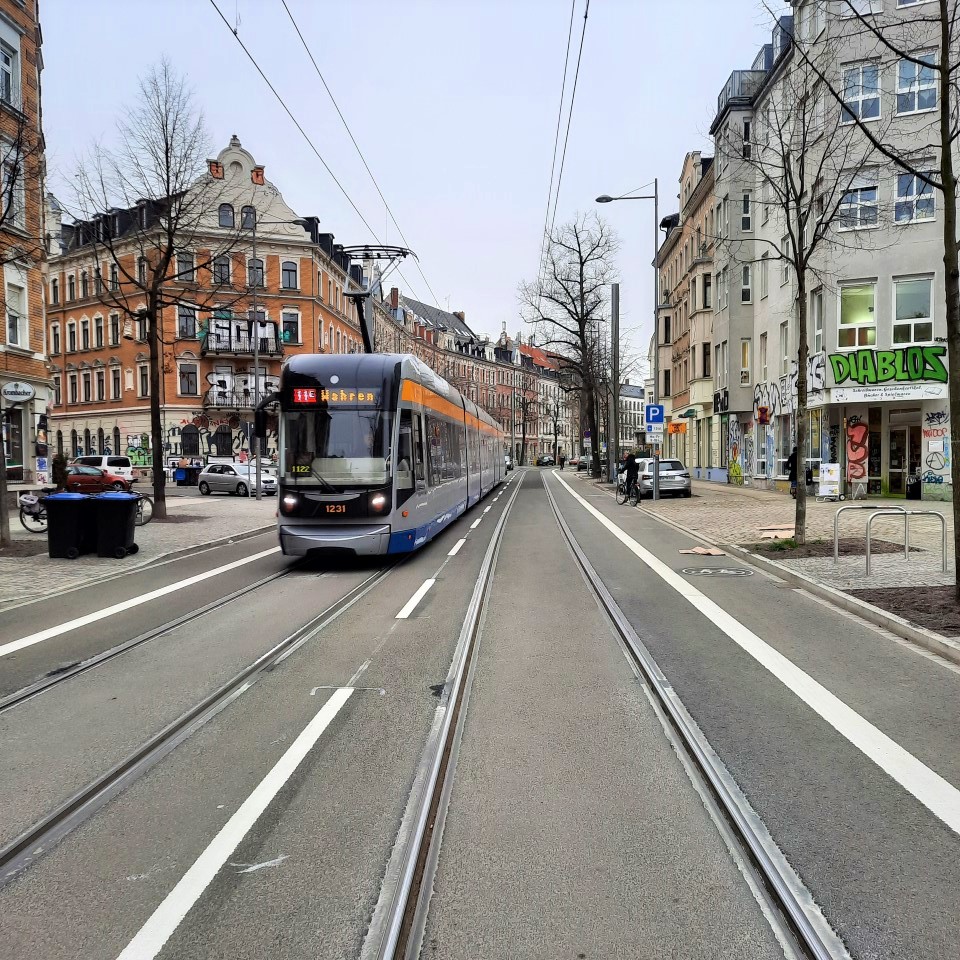 Bornaische Straße in Leipzig mit Radwegen, barrierefreier Haltestelle für die Straßenbahn, Straßenbäumen und breiten Gehwegen