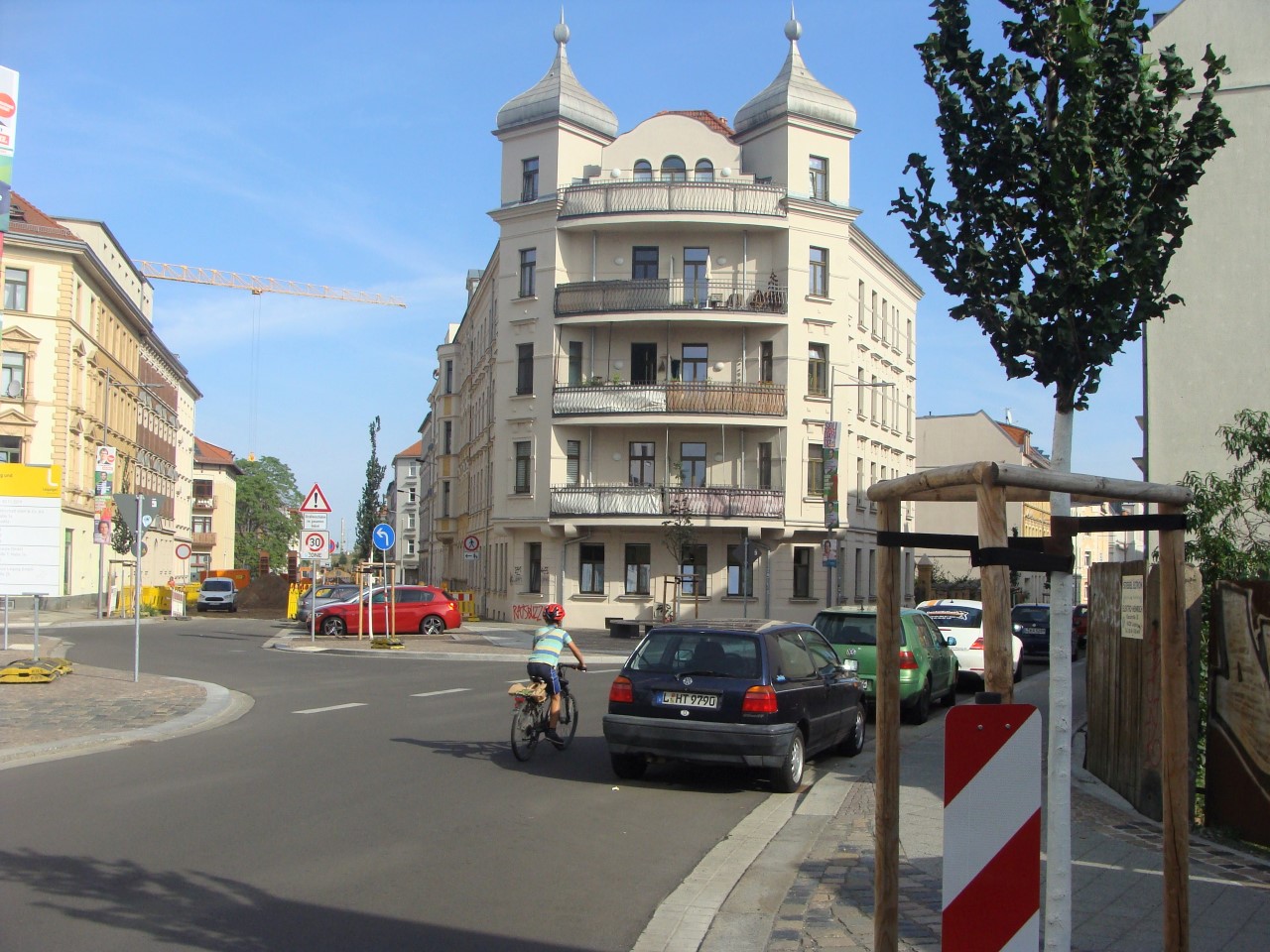 sanierter Kreuzungsbereich Creuzigerstraße und Gießerstraße. Ein Radfahrer biegt ab. Mutter und Kind wollen die Straße überqueren.
